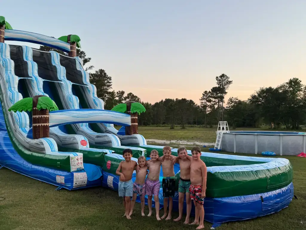 Kids standing in front of Tropical Tsunami water slide rental in Jacksonville NC by Elevation Inflatables